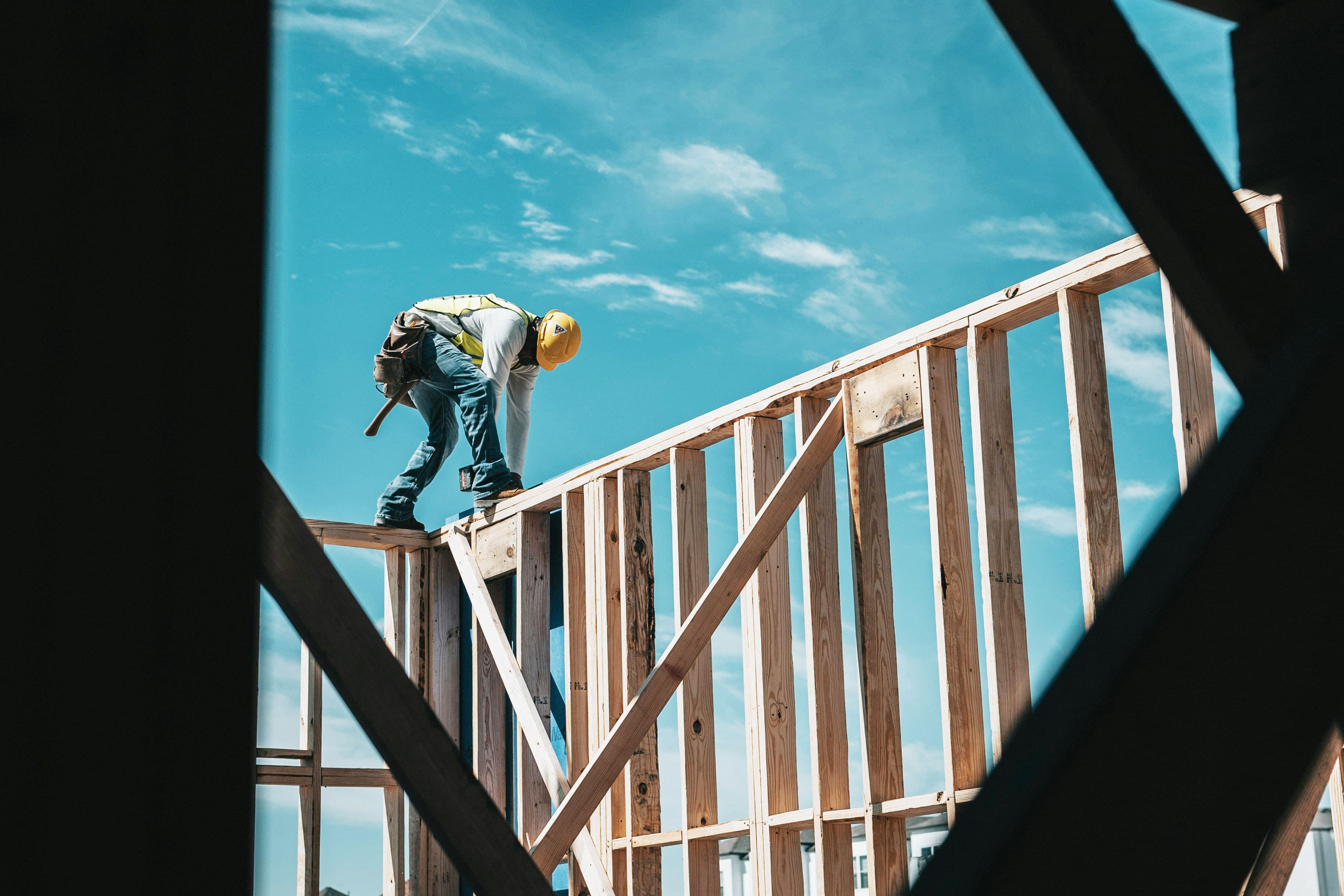 Construction worker standing on wooden structure.